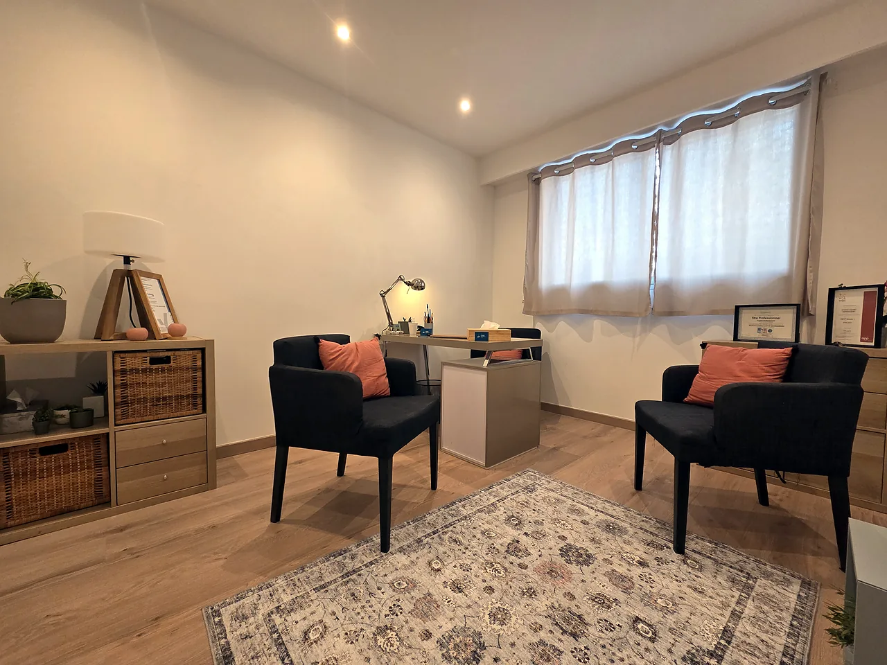 Le bureau de Christel Louvet à Nice : deux fauteuils face à face, un tapis et une fenêtre voilée
